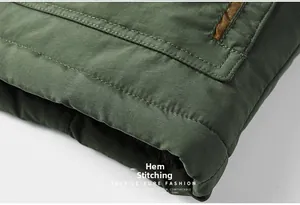Detail view of reinforced hemline stitching on a dark green vintage cotton jacket