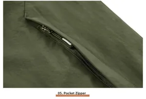 Detailed view of the olive green outdoor vest's zipper pocket with durable fabric