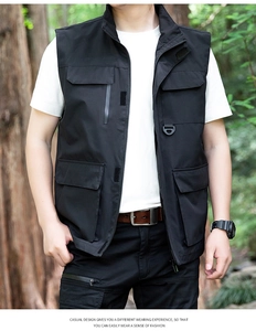 Close-up of black tactical vest with multiple utility pockets and D-ring in forest