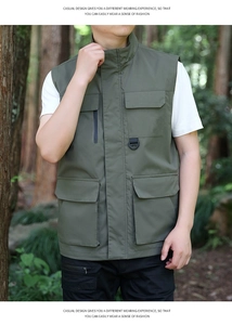 Detail of outdoor utility vest in olive green with multiple pockets and D-rings
