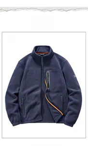 Détail de veste polaire bleu marine avec col montant et poche poitrine zippée orange