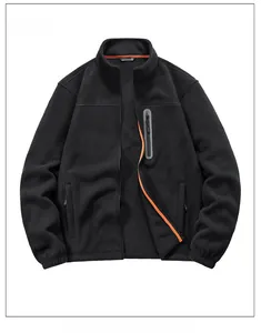 Détail d'une veste polaire noire avec col montant et doublure intérieure orange vif