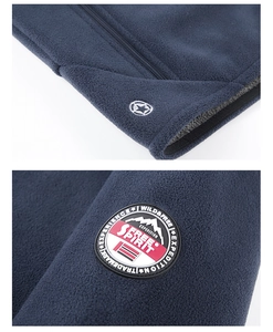 Detailansicht der dunkelblauen Fleecejacke mit Stern-Aufnäher und Textilstruktur