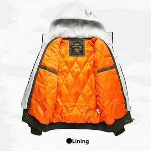 Close-up of olive green bomber jacket featuring orange quilted lining and grey hood