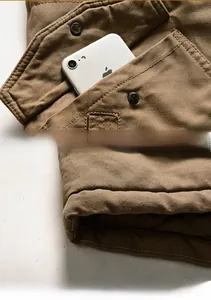 Detail view of the khaki winter jacket showing utility pockets and 3D hem construction
