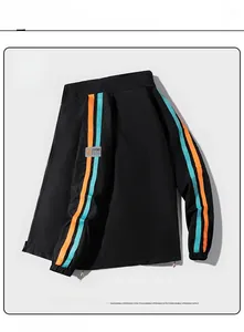 Détail de la veste de sport noire avec bandes orange et cyan et étiquette SPORT