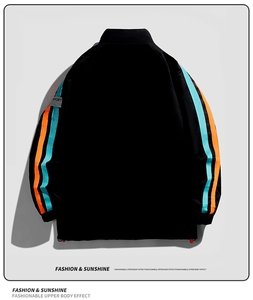 Détail de veste de sport noire avec bandes orange et bleues et étiquette tissée SPORT