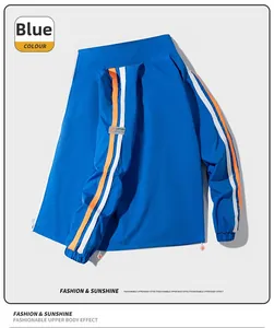 Détail de manche de veste bleue avec rayures blanches et orange et poignet élastique