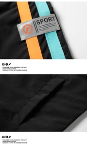 Détail de veste sport avec bandes orange et bleu et emblème gris Sport sur tissu noir