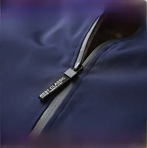 Detail of durable zipper with decorative ribbon and warm fleece lining on navy jacket