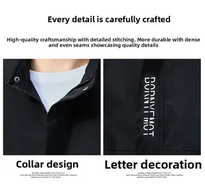 Detail der schwarzen Herrenjacke mit Stehkragen, Metallreißverschluss und weißem Buchstabendruck