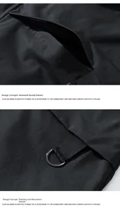 Detail view of black outdoor jacket featuring hemmed side pocket and metal D-ring ornament
