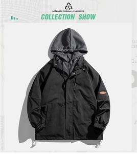 Detailed view of the layered hood and orange sleeve patch on a black casual jacket