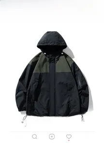 Détail de la veste bicolore montrant le tissu coupe-vent, la poche et l'ourlet ajustable