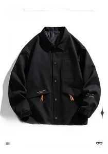 Detail of black utility jacket featuring orange strap accents and snap button closure