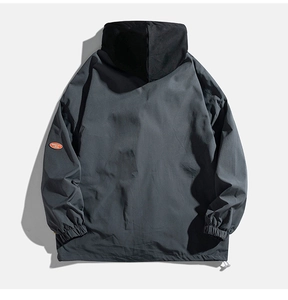 Close-up of dark grey hooded jacket with orange logo detail and adjustable drawstring