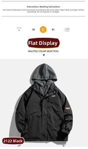 Détail de la veste noire à capuche avec effet superposé gris et badge orange sur le bras