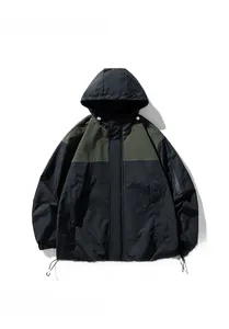 Détail de la veste d'extérieur imperméable avec panneaux contrastés olive et noir