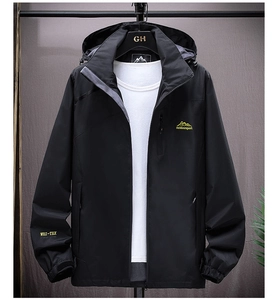 Close-up of black outdoor jacket featuring mountain embroidery and velcro adjustable cuffs