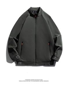 Detail of dark gray-green jacket showing orange U-zipper pulls and printed hem text