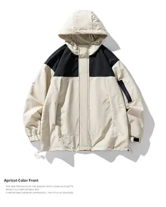 Détail de la veste imperméable abricot et noir avec capuche et poche sur la manche