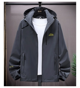 Detail of waterproof outdoor jacket featuring a yellow mountain embroidery and velcro cuffs