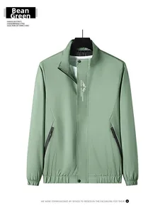 Detail of a men's stand collar jacket in bean green with zipper and logo print
