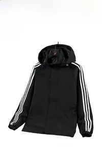 Detail of black sports jacket with hood, three white stripes on sleeve and zip closure