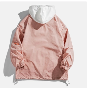 Détail de la veste à capuche rose montrant les poignets et le logo sur la manche