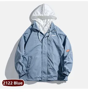 Détail d'une veste à capuche bleue avec effet deux-pièces et cordon de serrage blanc