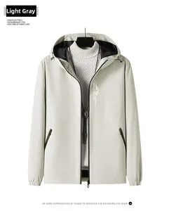 Détail d'une veste coupe-vent gris clair avec capuche à cordon et fermeture éclair étanche