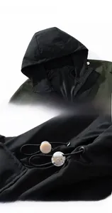 Détail du cordon de serrage de la capuche sur veste outdoor imperméable verte et noire