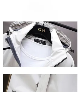 Detailed close-up of hooded outdoor jacket collar with adjustable drawstrings and labels