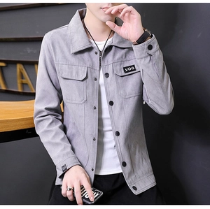 Dettaglio giacca scamosciata grigia con tasche a patta simmetriche e patch logo VOG