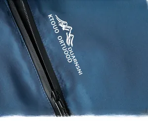 Détail macro d'une veste de randonnée imperméable avec fermeture éclair et logo blanc