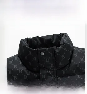Detail of black puffer vest featuring high collar and monogram letter B pattern print