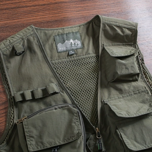 Detailed macro view of army green multi-pocket tactical vest with durable mesh lining