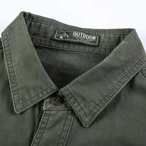 Détail du col d'une chemise en coton vert armée avec double couture et boutons métalliques