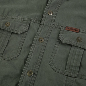 Détail d'une chemise de travail en coton vert armée avec étiquette en cuir et boutons
