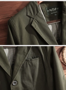 Close-up of olive green casual jacket with striped lining and vintage breast pockets