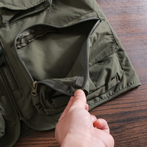 Close-up of durable zipper pocket and rugged fabric on military green cargo vest