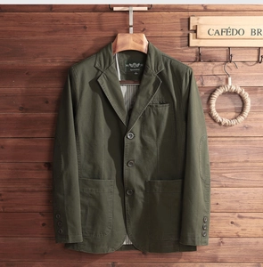 Detail of army green cotton blazer featuring elbow patches and stylish large patch pockets