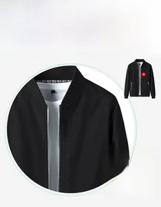 Detail einer schwarzen Stehkragenjacke mit BE AN ARTIST OF LIFE Bestickung auf der Brust