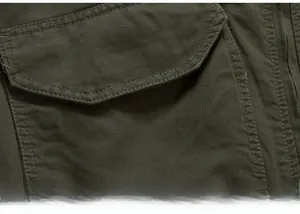 Macro view of army green cargo jacket featuring durable cotton twill and double-stitched pocket