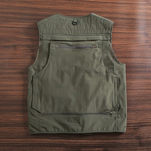 Detail view of military green outdoor vest with breathable mesh and zippered back pockets