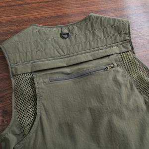 Detail view of military green utility vest featuring breathable mesh back and zipper pocket