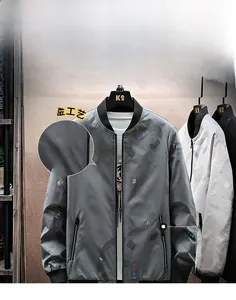 Detail der grauen Bomberjacke mit Regenbogen-Buchstabendruck und Metallreißverschluss