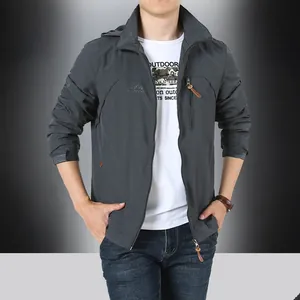 Detail der dunkelgrauen Outdoor-Jacke mit Reißverschlusstaschen, Kapuze und Logo
