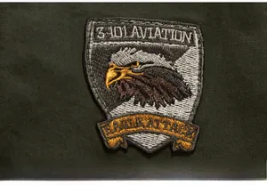 Detail of military eagle embroidery patch with 3-101 Aviation text on green jacket
