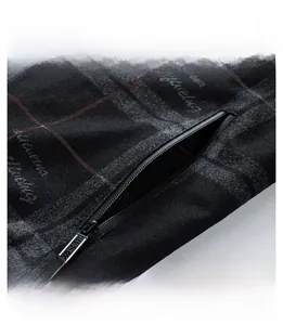 Detail of the zipper pocket on a men's jacket with dark textured fabric and red accents
